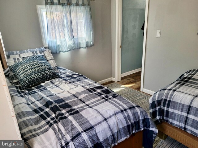 bedroom with wood finished floors and baseboards