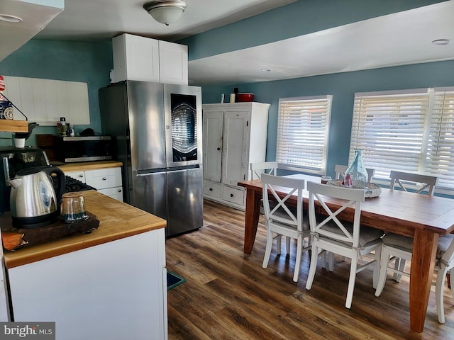 kitchen featuring white cabinets, butcher block counters, plenty of natural light, and stainless steel appliances