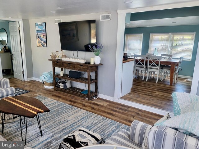 living room featuring wood finished floors, baseboards, and visible vents