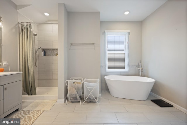 bathroom featuring a soaking tub, a shower stall, vanity, recessed lighting, and baseboards