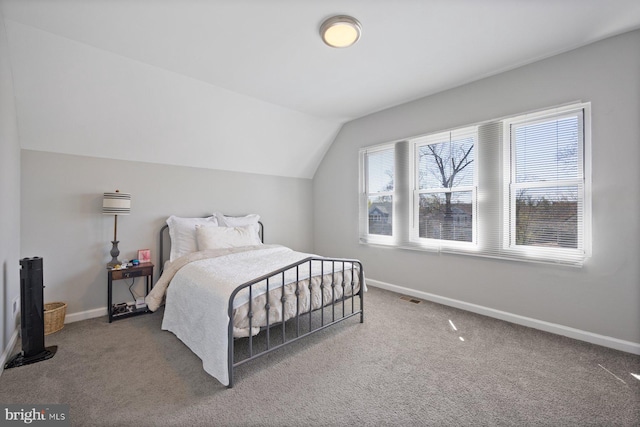 carpeted bedroom featuring baseboards, lofted ceiling, and visible vents