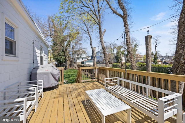 wooden deck with a residential view, a grill, and fence