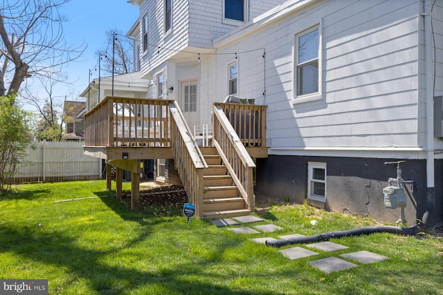 exterior space featuring a yard, stairway, a wooden deck, and fence