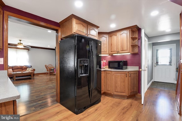 kitchen featuring wood finished floors, baseboards, recessed lighting, light countertops, and black appliances