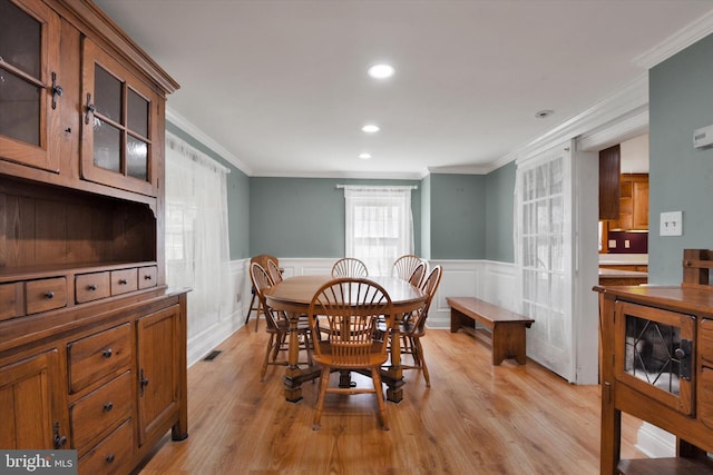 dining area featuring light wood-style floors, a wainscoted wall, ornamental molding, and recessed lighting