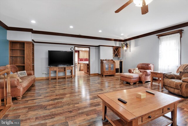 living area featuring a ceiling fan, wood finished floors, baseboards, ornamental molding, and recessed lighting