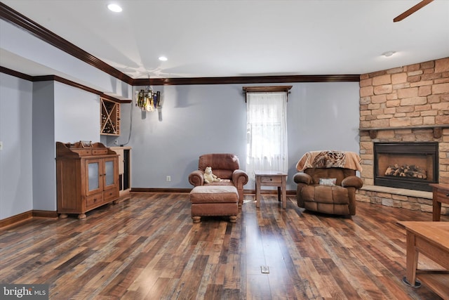living area with a stone fireplace, ornamental molding, baseboards, and hardwood / wood-style floors