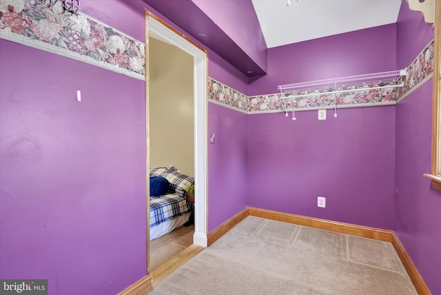 carpeted empty room featuring baseboards