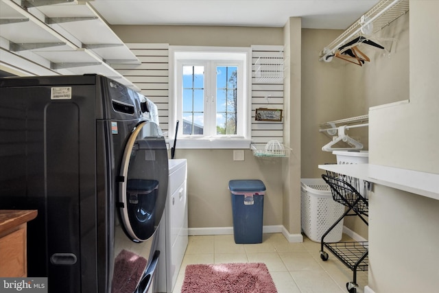 laundry room featuring baseboards, laundry area, washer and clothes dryer, and tile patterned flooring