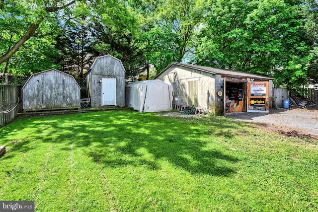 view of yard with fence, a storage unit, and an outdoor structure