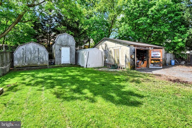 view of yard with fence, a storage unit, and an outdoor structure