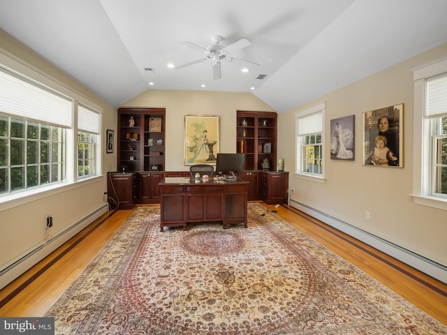 home office with ceiling fan, a baseboard heating unit, vaulted ceiling, and light wood finished floors