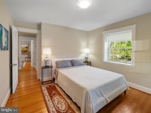 bedroom with light wood-style floors and baseboards