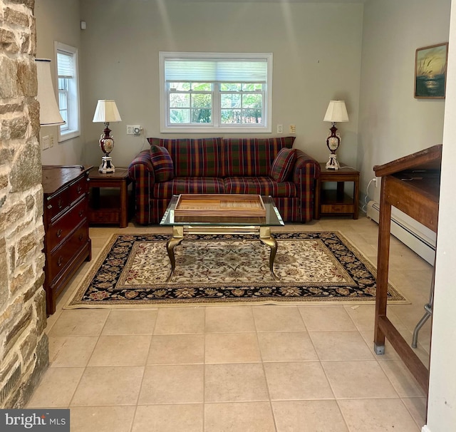 living area featuring tile patterned flooring, a healthy amount of sunlight, and a baseboard heating unit