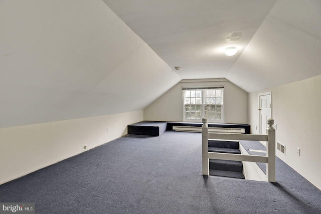 additional living space with vaulted ceiling, carpet, visible vents, and a baseboard radiator