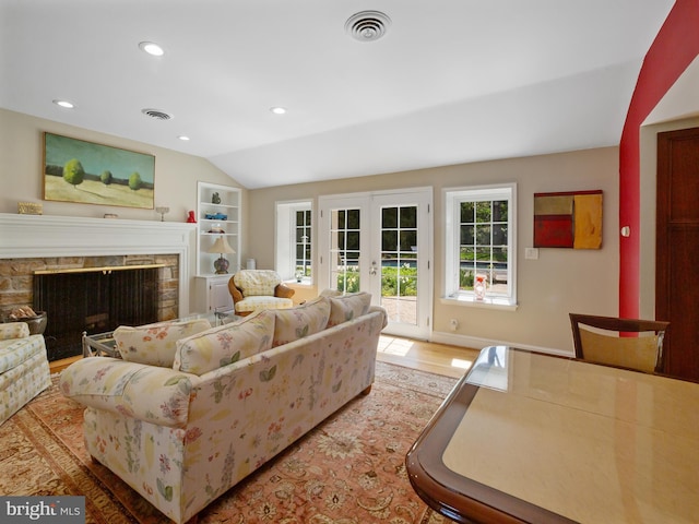 living room featuring french doors, visible vents, a fireplace, lofted ceiling, and recessed lighting