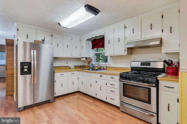 5605 Chapmans Landing Rd, Indian Head, MD 20640 - kitchen featuring appliances with stainless steel finishes, under cabinet range hood, light countertops, light wood finished floors, and a textured ceiling