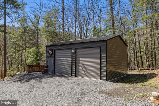 detached garage featuring a forest view