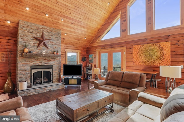 living area featuring wood walls, wooden ceiling, wood finished floors, and a fireplace
