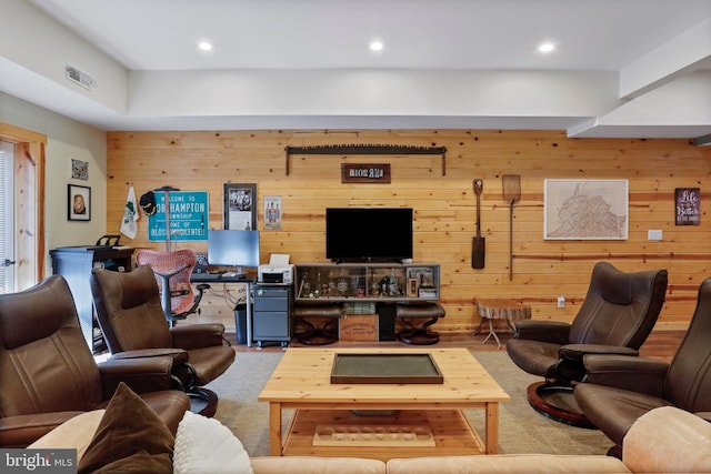 carpeted living area with wood walls and recessed lighting