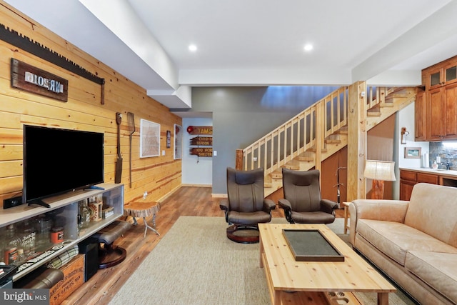 living room with wood walls, stairs, recessed lighting, and wood finished floors
