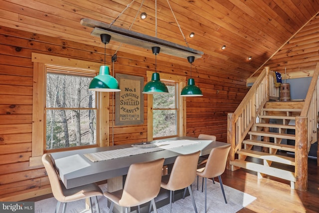 dining space featuring wooden ceiling, wooden walls, wood finished floors, stairs, and lofted ceiling