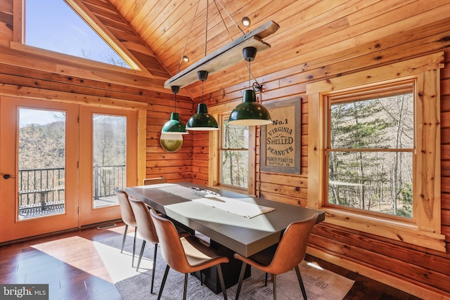 dining space with a healthy amount of sunlight, wooden walls, wooden ceiling, and lofted ceiling
