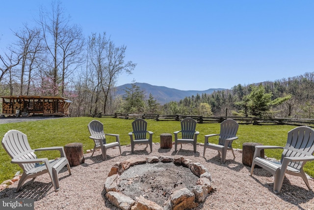 view of yard featuring fence, a patio, a mountain view, and an outdoor fire pit