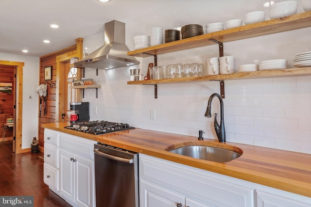kitchen featuring island exhaust hood, open shelves, wooden counters, stainless steel appliances, and a sink
