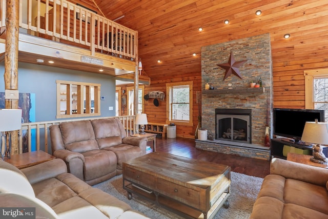 living area featuring wooden walls, wood ceiling, hardwood / wood-style flooring, and a fireplace