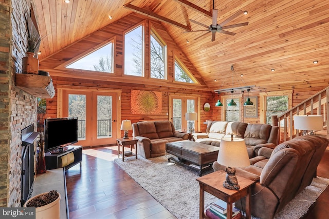 living room with high vaulted ceiling, ceiling fan, wood ceiling, wood finished floors, and wooden walls