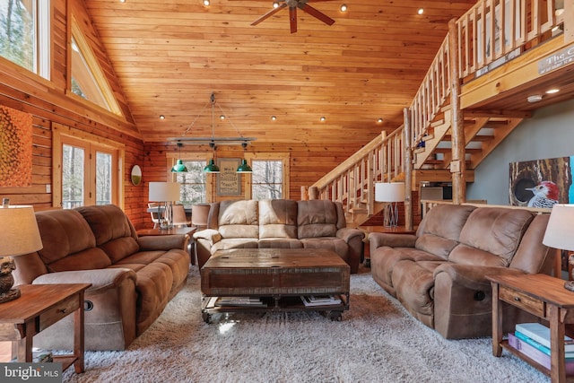 living area with ceiling fan, vaulted ceiling, carpet floors, stairway, and wood ceiling