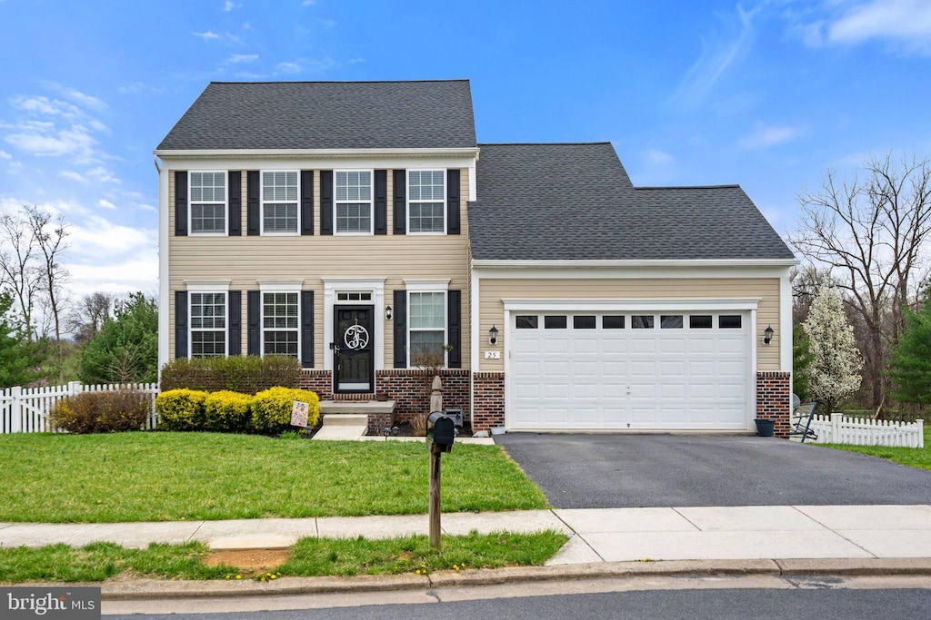 view of front of property with driveway, fence, brick siding, and a garage