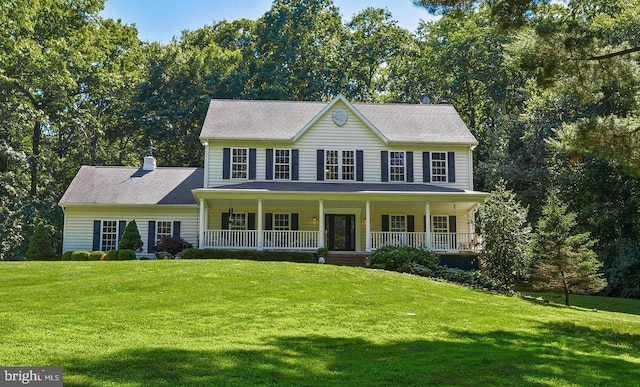 colonial-style house featuring covered porch and a front lawn