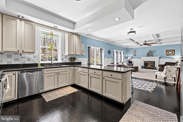 kitchen featuring a fireplace, a peninsula, a ceiling fan, stainless steel dishwasher, and a sink