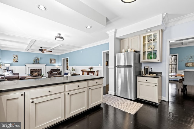 kitchen with crown molding, freestanding refrigerator, ceiling fan, dark countertops, and coffered ceiling
