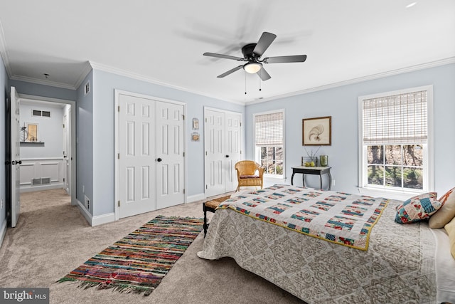 bedroom featuring visible vents, multiple closets, multiple windows, and carpet