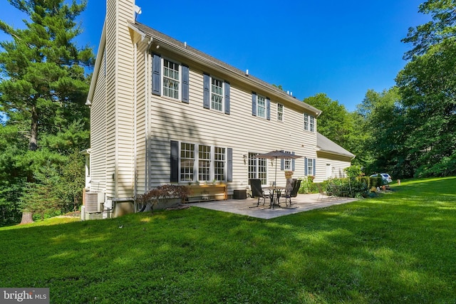 back of property with a patio, a chimney, and a yard
