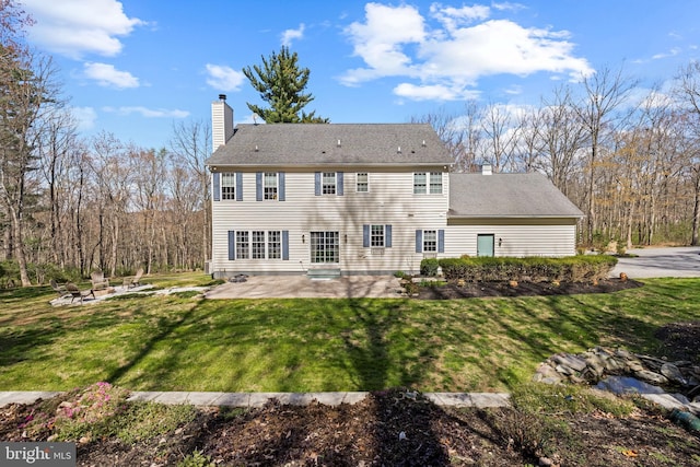 back of property with an outdoor fire pit, a patio, a lawn, and a chimney