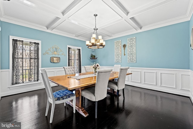 dining space with a chandelier, dark wood-type flooring, a wainscoted wall, and coffered ceiling