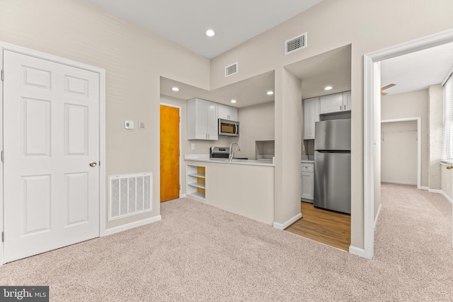 1516 Lancaster St, Baltimore, MD 21231 - kitchen featuring appliances with stainless steel finishes, light colored carpet, white cabinetry, light countertops, and recessed lighting