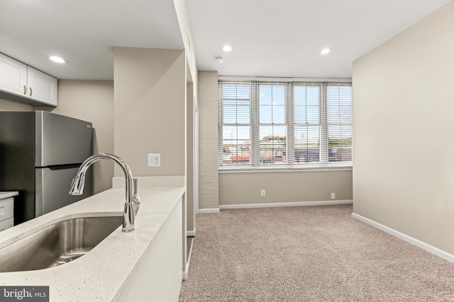 1516 Lancaster St, Baltimore, MD 21231 - kitchen with freestanding refrigerator, light colored carpet, white cabinetry, recessed lighting, and light stone counters