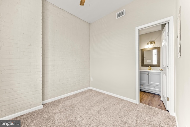 1516 Lancaster St, Baltimore, MD 21231 - unfurnished bedroom with carpet, brick wall, ensuite bathroom, and a ceiling fan