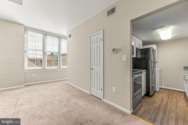 1516 Lancaster St, Baltimore, MD 21231 - kitchen featuring stainless steel appliances, white cabinets, and carpet floors
