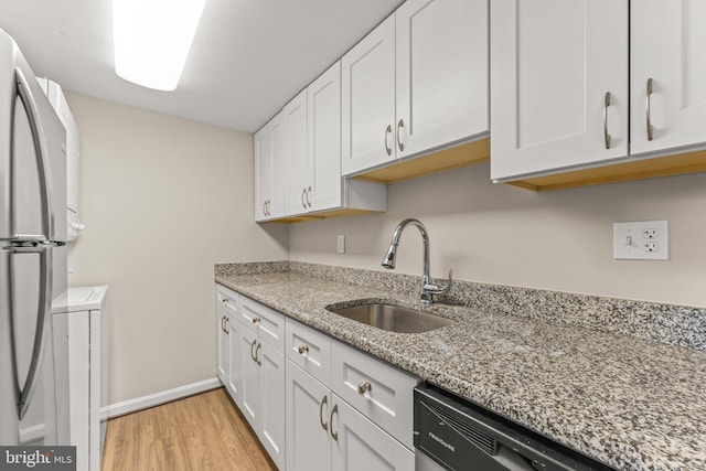 1516 Lancaster St, Baltimore, MD 21231 - kitchen with freestanding refrigerator, light wood-style floors, white cabinetry, light stone counters, and dishwasher