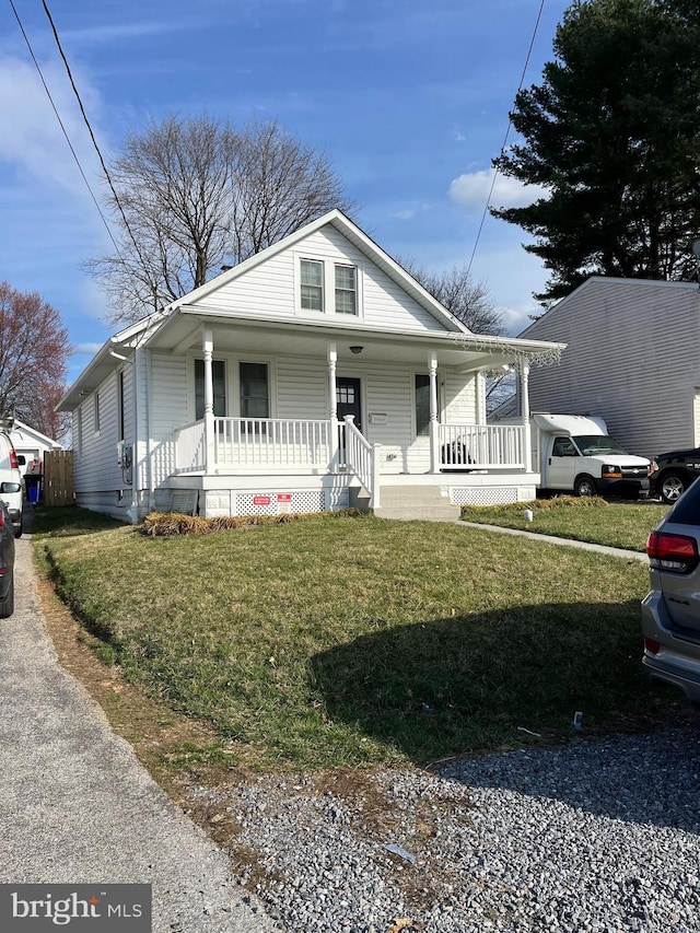 bungalow with a front yard and covered porch