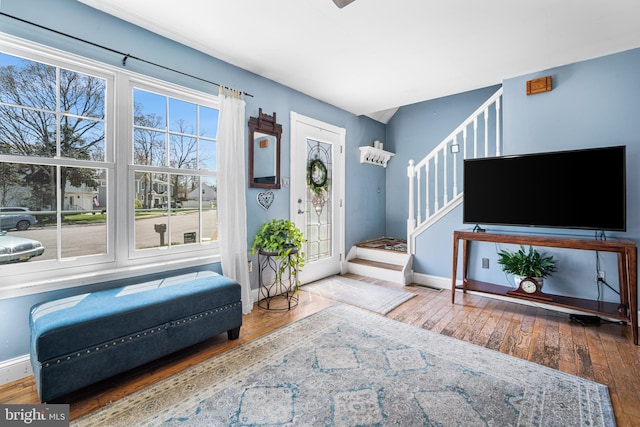 interior space featuring hardwood / wood-style floors, baseboards, and stairway