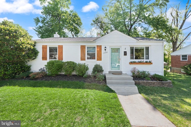 11809 Old Drovers Way, Rockville, MD 20852 - view of front of house with a front yard, a chimney, and brick siding