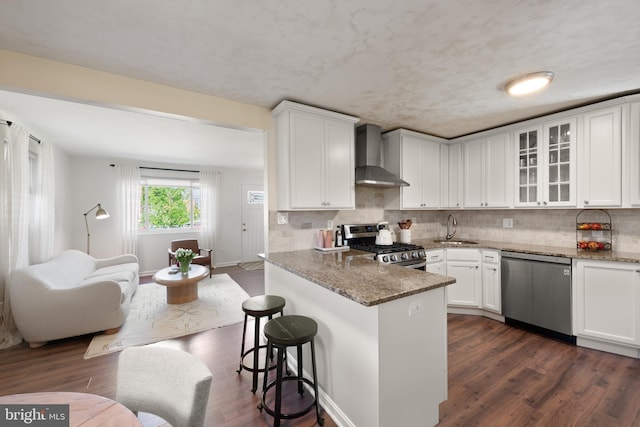 11809 Old Drovers Way, Rockville, MD 20852 - kitchen featuring stainless steel appliances, wall chimney range hood, a sink, white cabinetry, and stone counters