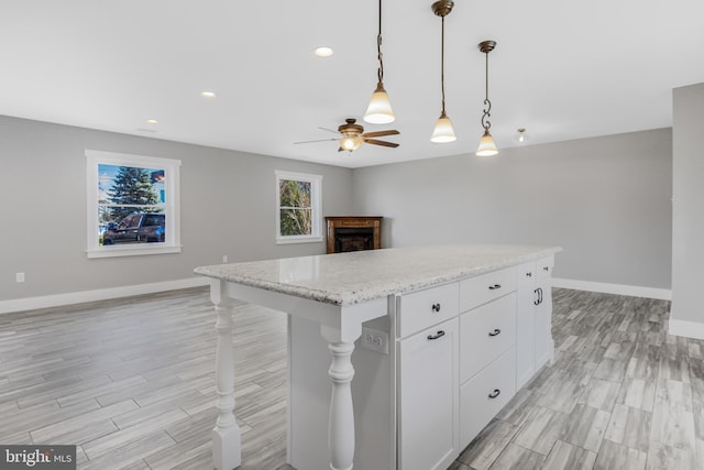 123 Somerset Rd, Stevensville, MD 21666 - kitchen featuring baseboards, a ceiling fan, a fireplace, open floor plan, and light wood-style flooring